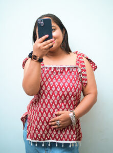 Sleeveless short kurti for women in maroon with white prints, lace detailing, and backless design