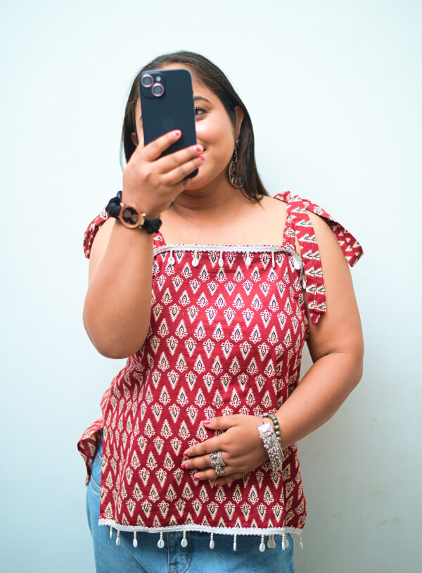 Sleeveless short kurti for women in maroon with white prints, lace detailing, and backless design